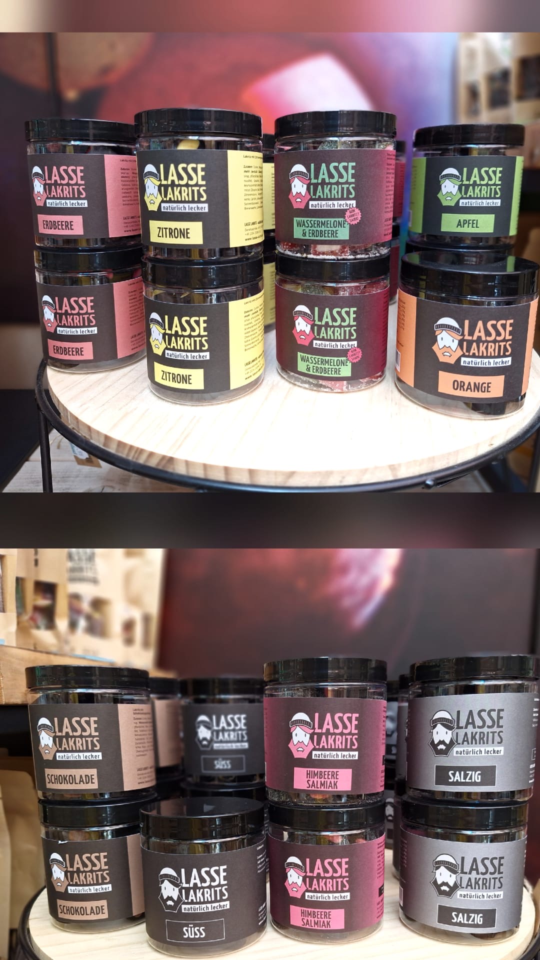 Verschiedene Lasse Lakrits Dosen mit Geschmacksrichtungen wie Zitrone, Orange, Apfel, Himbeere, Schokolade und salzig auf einem runden Holztisch