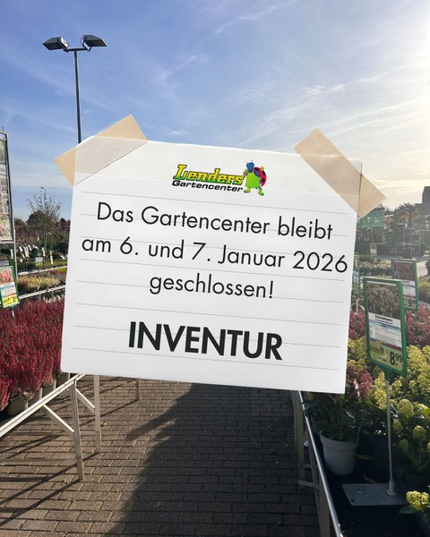 Schild mit der Aufschrift 'Das Gartencenter bleibt am 6. und 7. Januar 2026 geschlossen! INVENTUR' vor einem Gartencenter mit Pflanzen und Verkaufsständen